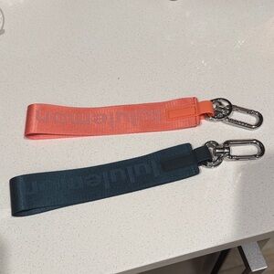2 NEVER LOST KEYCHAINS LULULEMON NWOT dark teal blue and peach coral